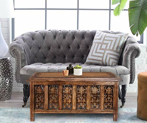 Gray tufted sofa with a patterned pillow and a wooden coffee table in front.