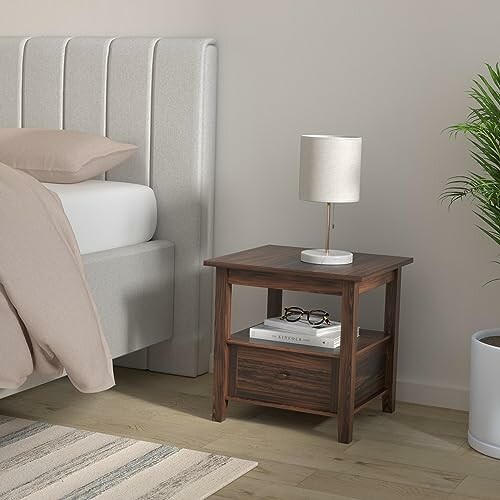 Modern bedroom with a wooden nightstand, lamp, and a plant.