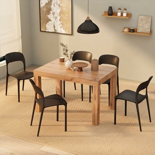 Modern dining room with wooden table, black chairs, and decor.