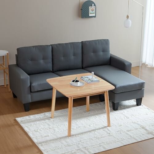 Modern gray sofa with a wooden coffee table in a minimalist living room.