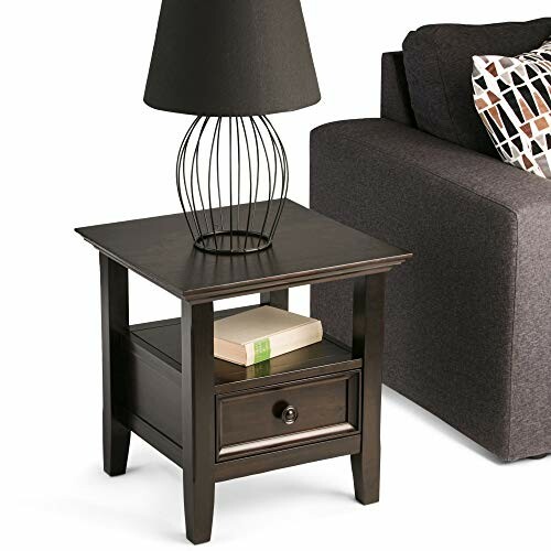 Modern side table with a lamp and book, next to a sofa.