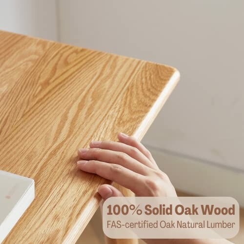 Hand touching solid oak wood table corner.