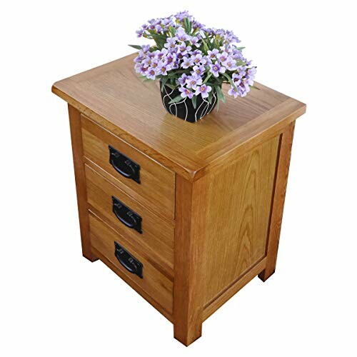 Wooden bedside table with three drawers and a pot of purple flowers on top.