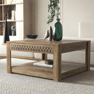 Wooden coffee table with decorative pattern, books, and vase in modern living room.