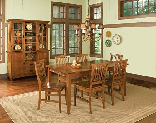 Wooden dining room set with chairs and chandelier in a bright room.